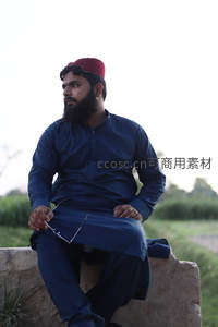 戴红帽男子静坐田埂沉思