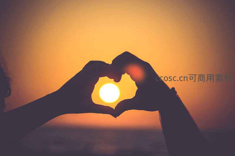 双手比心框住落日余晖剪影