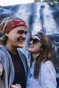 瀑布前甜蜜对视，情侣自拍记录旅行瞬间