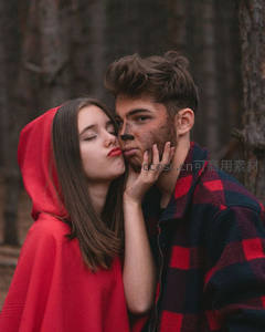 森林中红衣女子亲吻男友脸颊