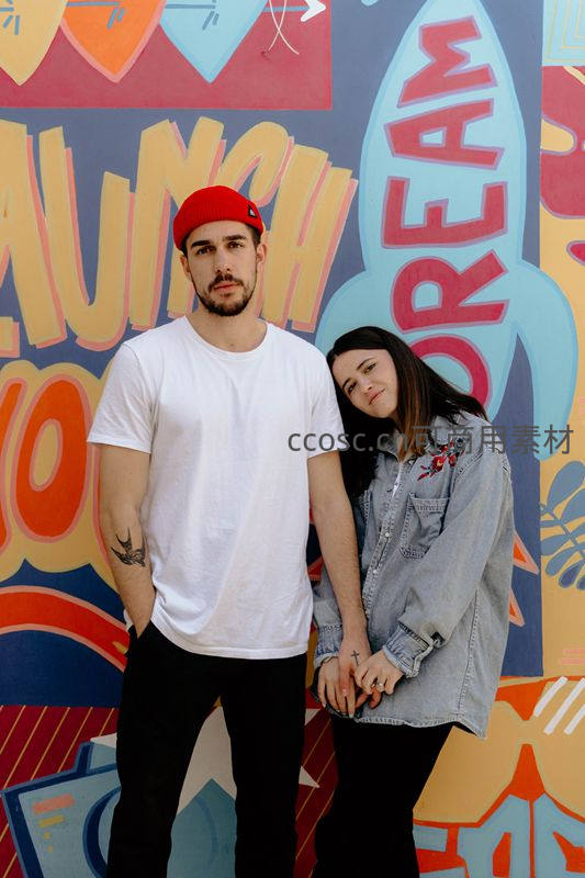 街头涂鸦墙前的时尚情侣