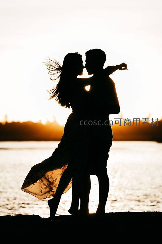 日落湖畔剪影中的浪漫拥吻