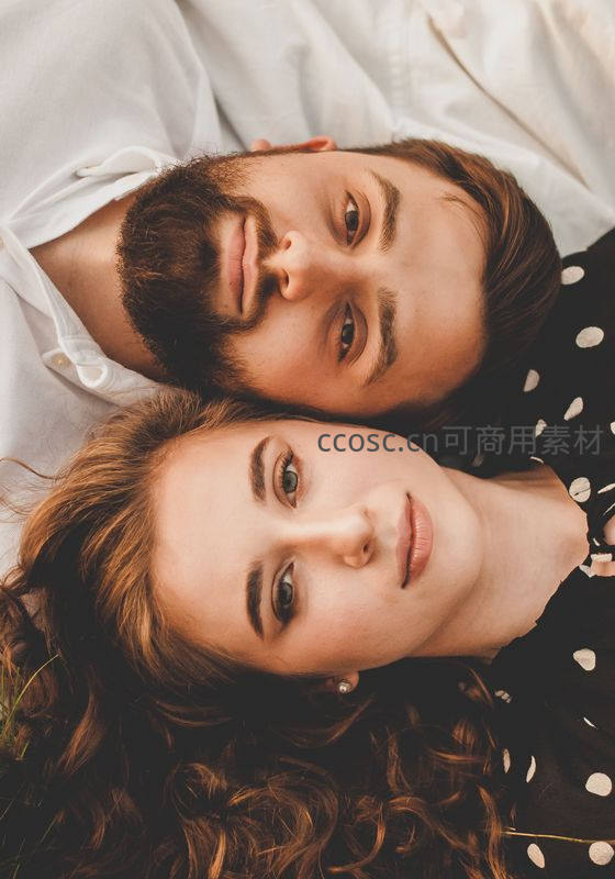 亲密依偎的恋人仰卧草地