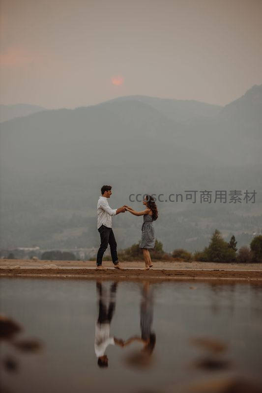 湖边情侣牵手倒影如画的黄昏