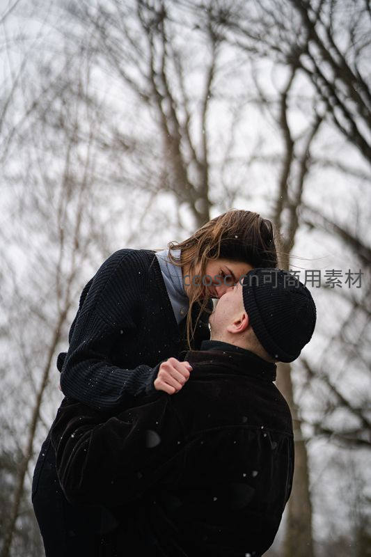 雪中情侣深情相拥亲吻的冬日