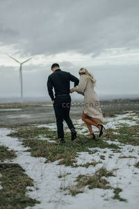 雪地奔跑的情侣与风车远景