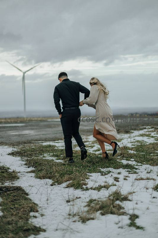 雪地奔跑的情侣与风车远景
