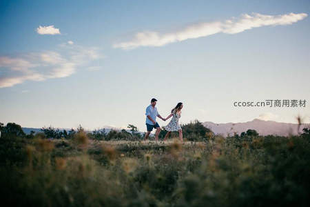 草原上奔跑牵手的幸福恋人
