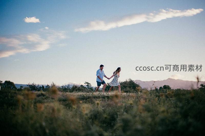 草原上奔跑牵手的幸福恋人