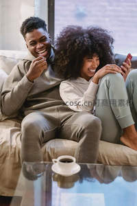 沙发上的欢笑时光，情侣共享手机乐趣