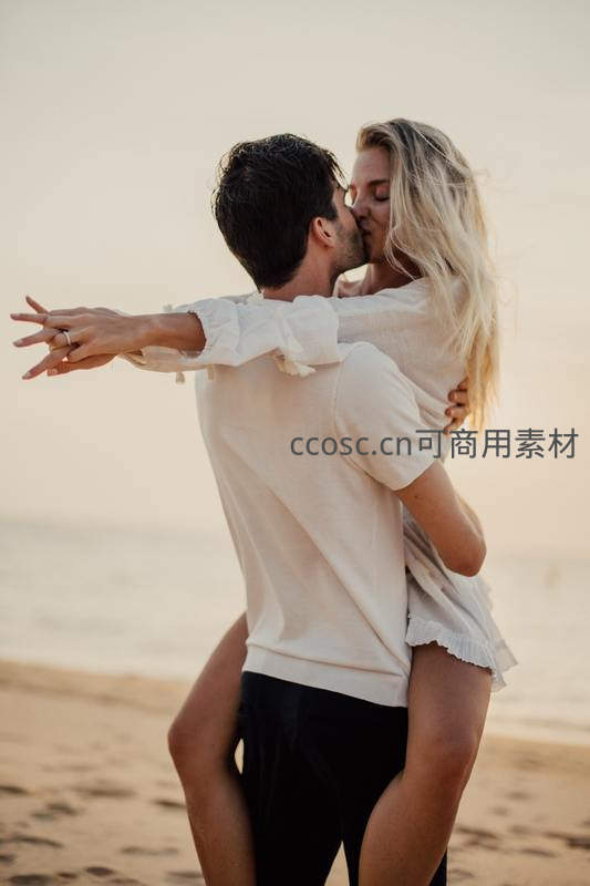 海滩夕阳下情侣深情拥吻