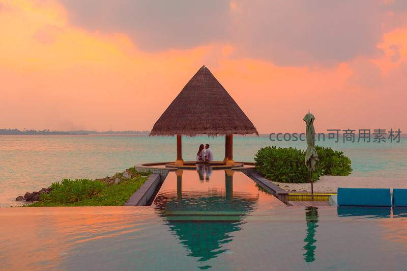 夕阳下的海岛泳池与情侣剪影