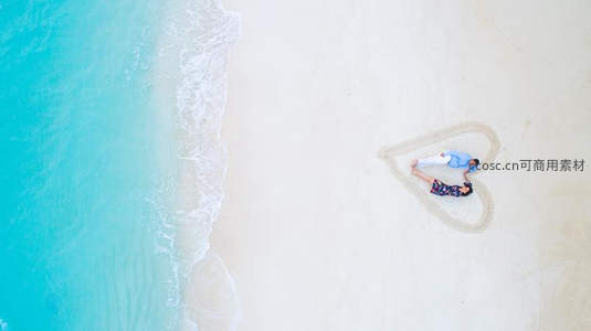 航拍心形沙滩情侣躺卧