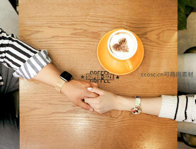 咖啡馆里的情侣手牵手，杯中拉花诉说甜蜜心事