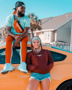 橙色跑车前的时尚情侣街拍