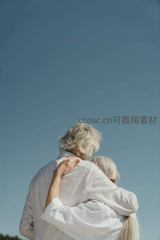 白发老人相拥仰望蔚蓝天空