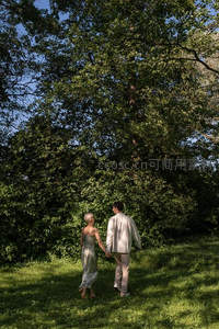 林间牵手漫步的恋人背影