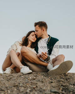 情侣依偎坐在沙地上