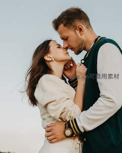 情侣深情对视，温柔相拥于晴空之下