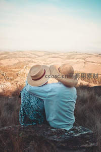 情侣戴草帽山顶远眺金色原野