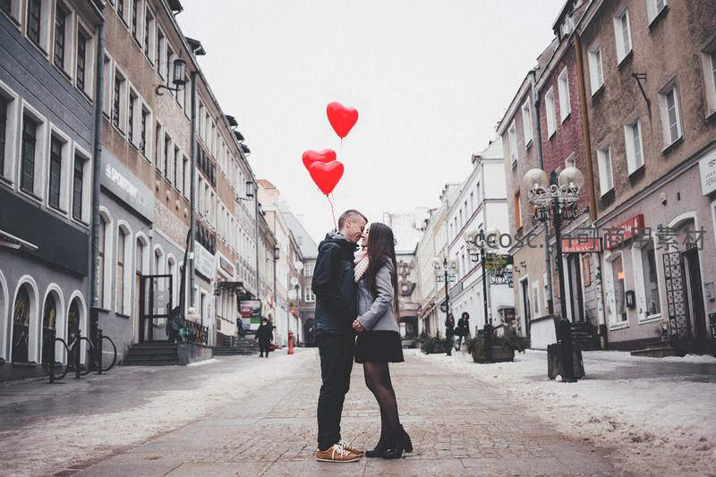 雪街拥吻的情侣与红心气球