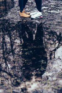 水洼倒影中的情侣脚步