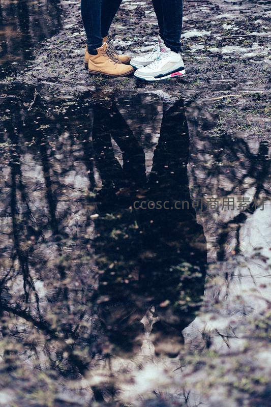 水洼倒影中的情侣脚步