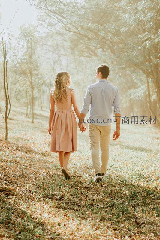 林间牵手漫步的甜蜜情侣