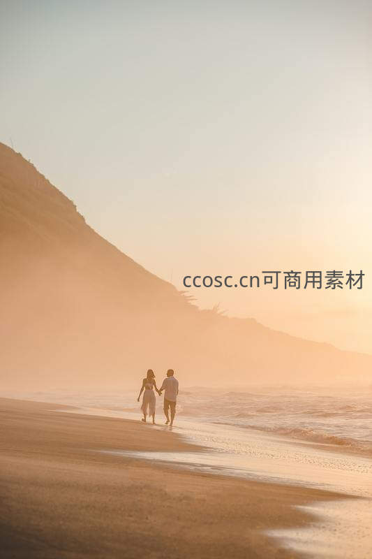 夕阳海滩情侣牵手漫步浪漫剪影