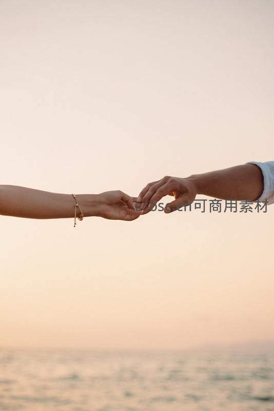 夕阳下海边牵手瞬间