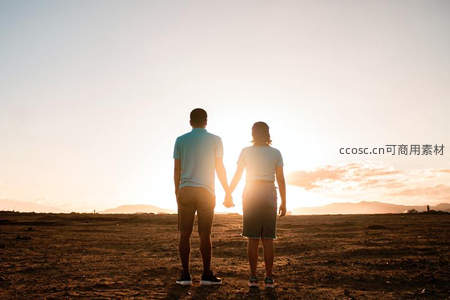 夕阳下牵手远眺的恋人剪影