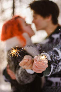 冬日雪景中手持烟花棒亲吻