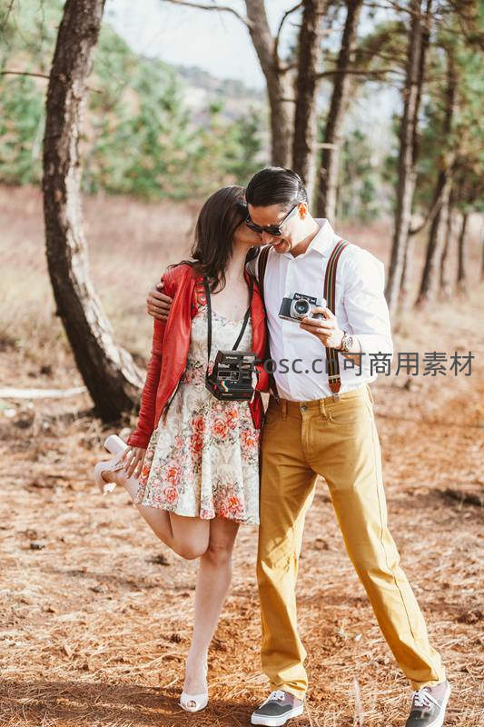 森林里相拥拍照的甜蜜情侣