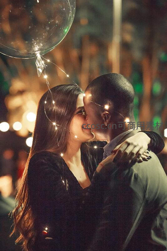 夜市灯光下情侣深情相拥亲吻瞬间