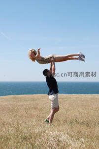 海边草地上抛起爱人