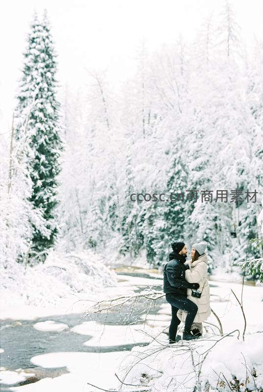 雪林溪畔，恋人相拥共赏冬日美景