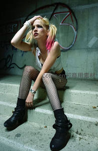 朋克少女坐阶沉思，涂鸦墙下展现叛逆风格