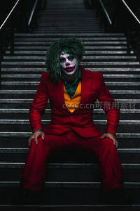 小丑妆容男子坐于阶梯中央