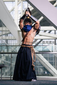 现代建筑内武士挥刀，肌肉与传统服饰交融