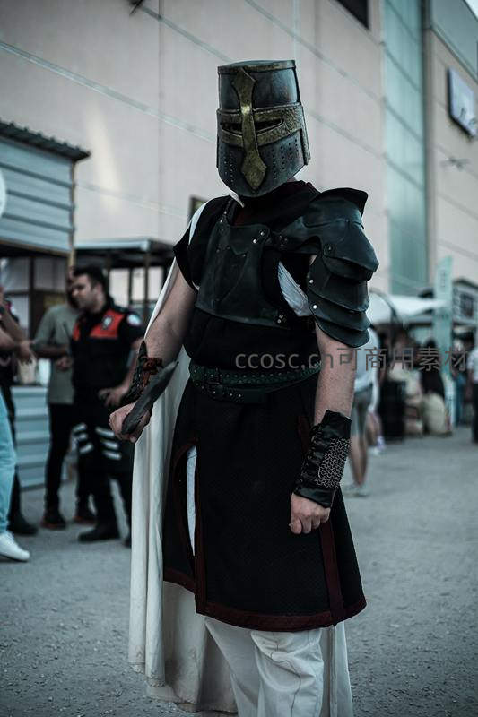 重甲战士头戴铁盔，手持利刃街头伫立