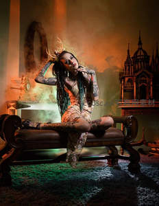 纹身女子戴鹿角头饰坐复古沙发