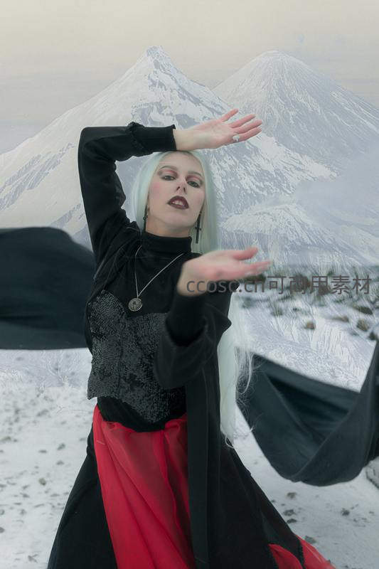 雪峰前白发女子舞动红黑长裙