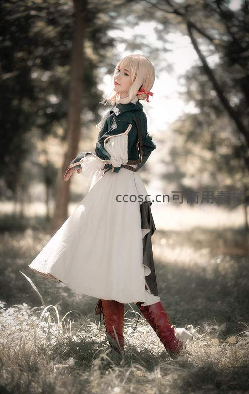 林间少女身着绿白裙装，红靴轻点草丛