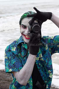 小丑妆容男子海边持相机自拍