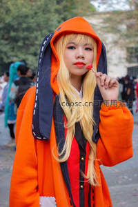 橙色连帽衫少女含糖棒微笑街头