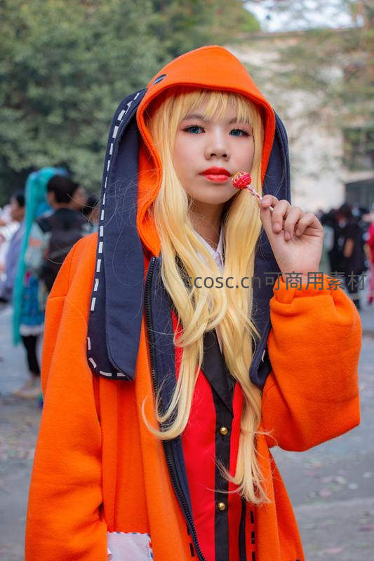 橙色连帽衫少女含糖棒微笑街头