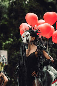 面具舞者手持红气球街头表演