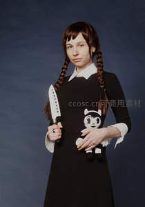 持刀少女抱玩偶冷峻凝视