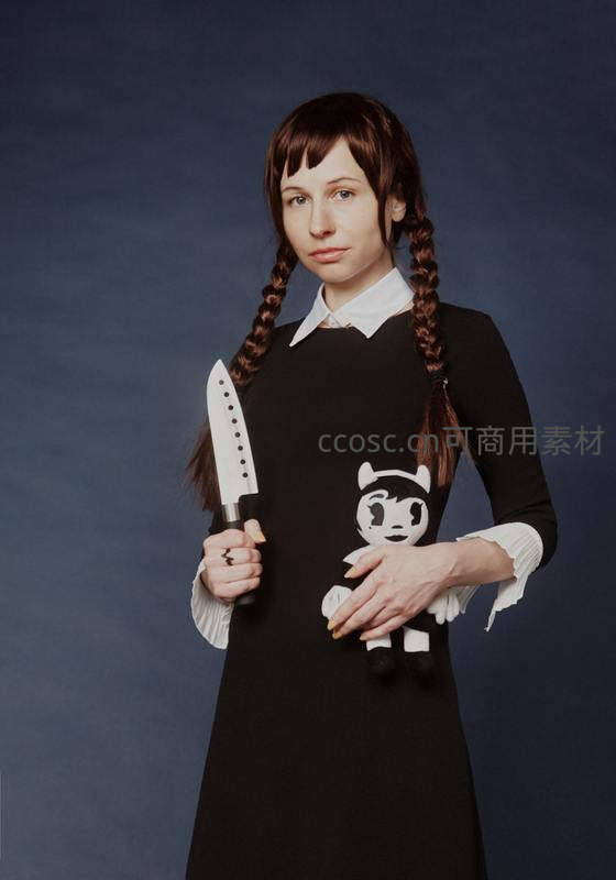 持刀少女抱玩偶冷峻凝视