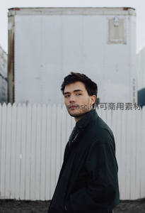 工业背景前回眸凝视的青年男子